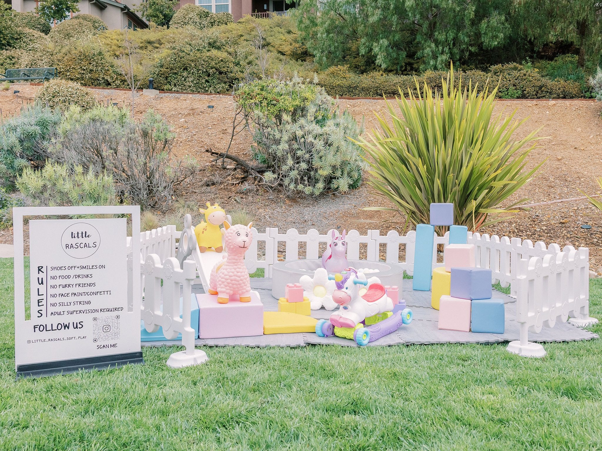 A pastel soft play set laid out in a backyard