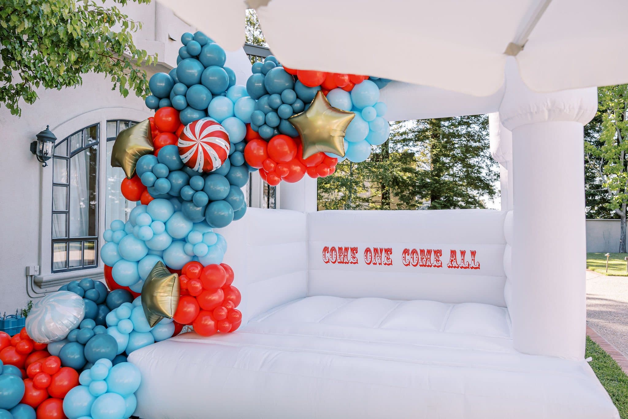Bounce house framed by a balloon garland