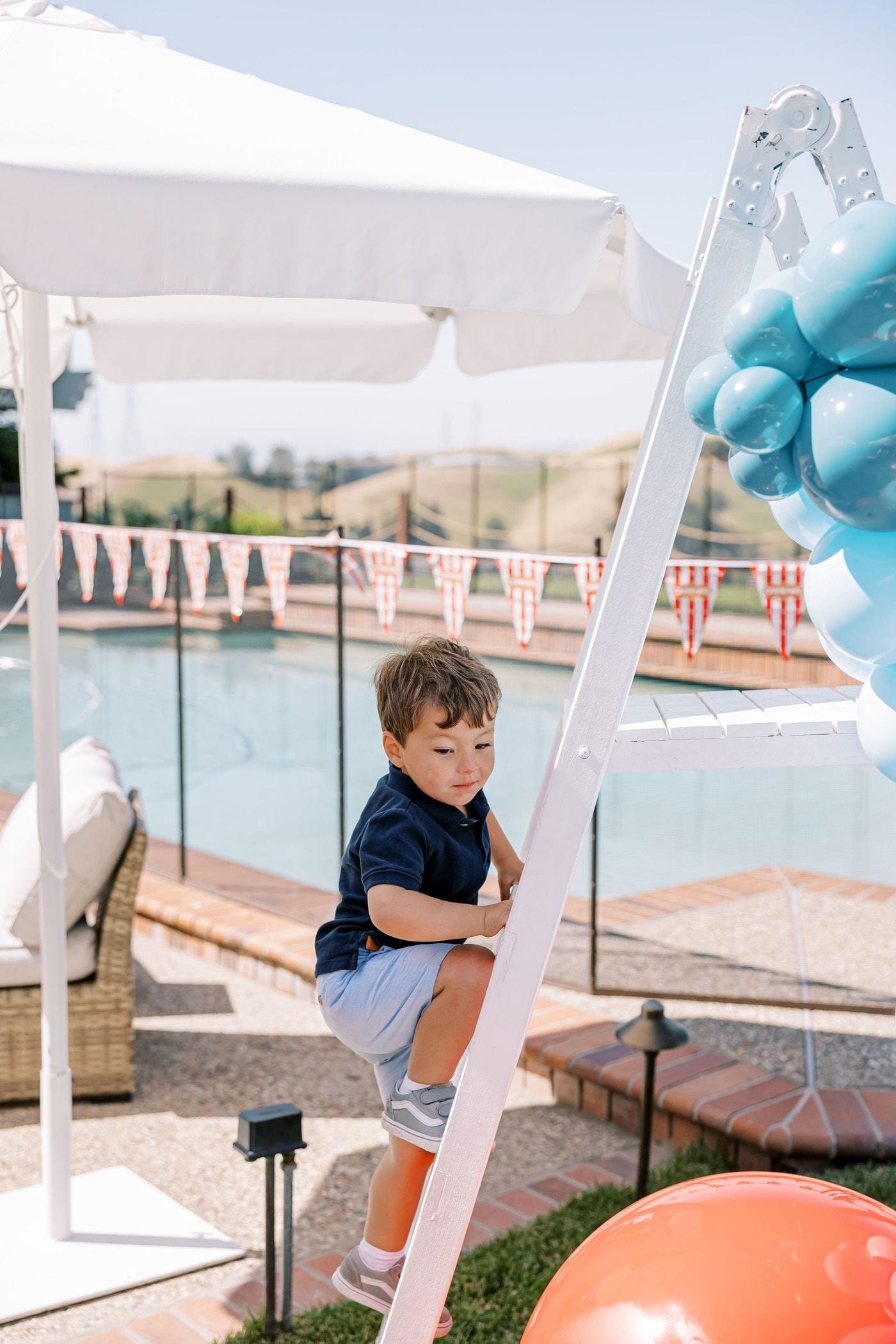 Kids on a bounce house slide at a carnival-themed party