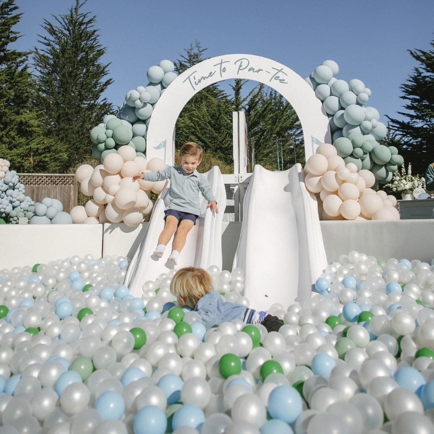 A child on a slide at a backyard party