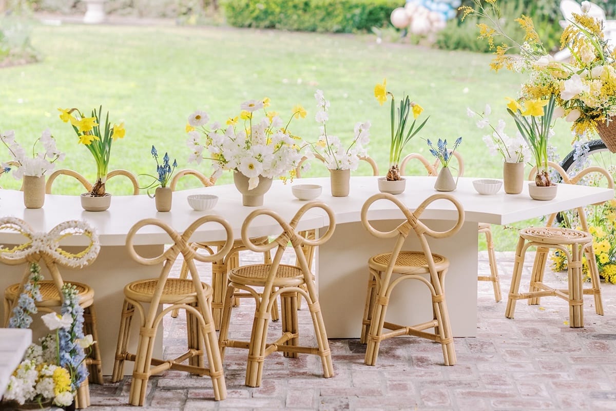 Rattan bow chairs around a kids table in a garden